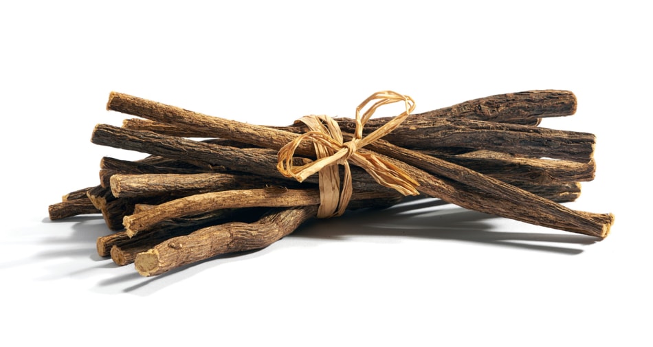 Licorice sticks tied together against a white background.