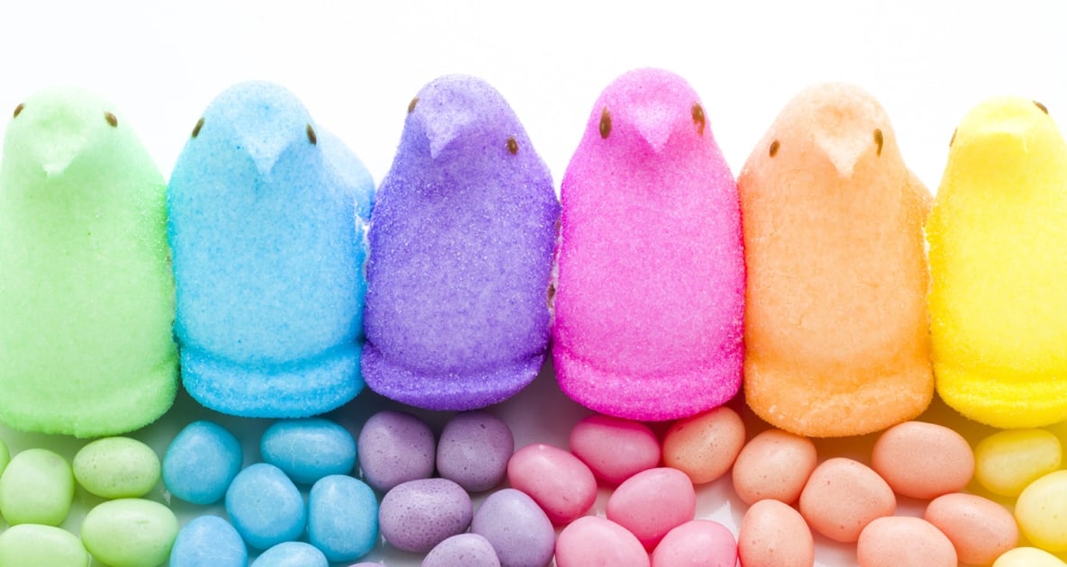A variety of different colored marshmallow peeps with similarly colored jelly beans.