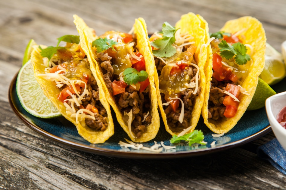 Mexican tacos with beef, cheese, tomato and green salsa.