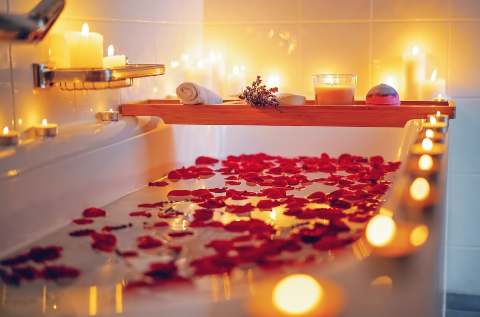 Spiritual aura cleansing flower bath for full moon ritual with candles, aroma salt, lavender and rose petals. Body care and mental health routine.