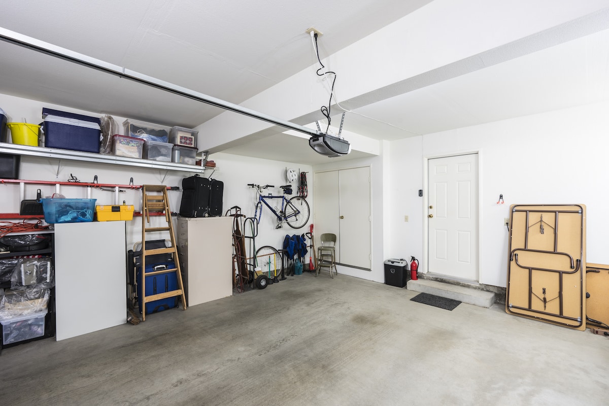Organized garage shelves with sealed bins, removing dark spaces that attract spiders