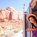 Woman hanging out the back of a camper van