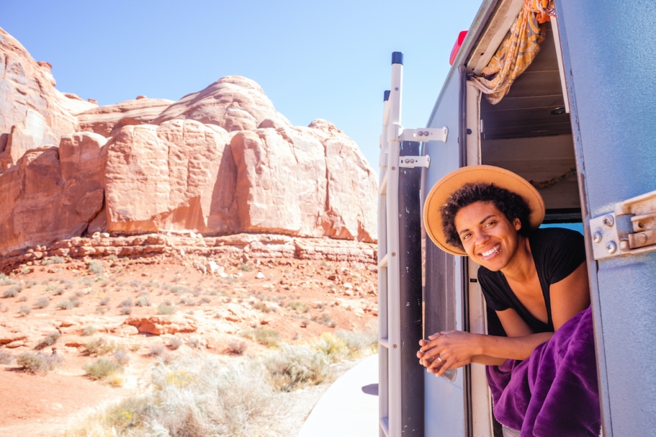 Woman hanging out the back of a camper van