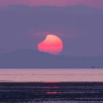 sunrise solar eclipse over the ocean