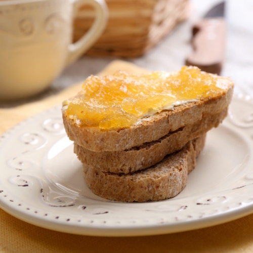 Fresh toast with butter and corncob jelly on table close up