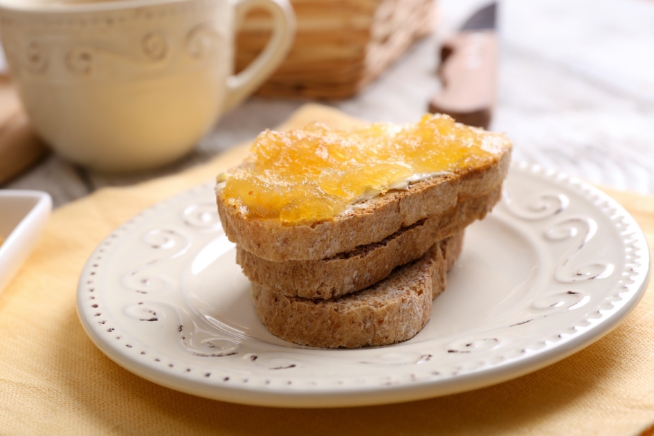 Fresh toast with butter and corncob jelly on table close up