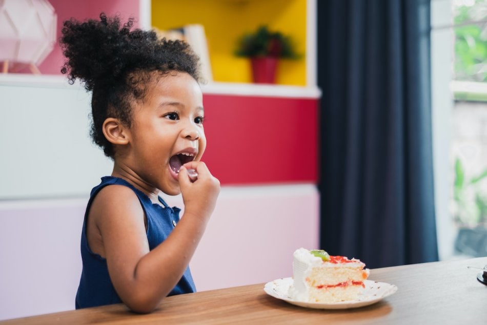 Young girl enjoying her piece of birthday cake