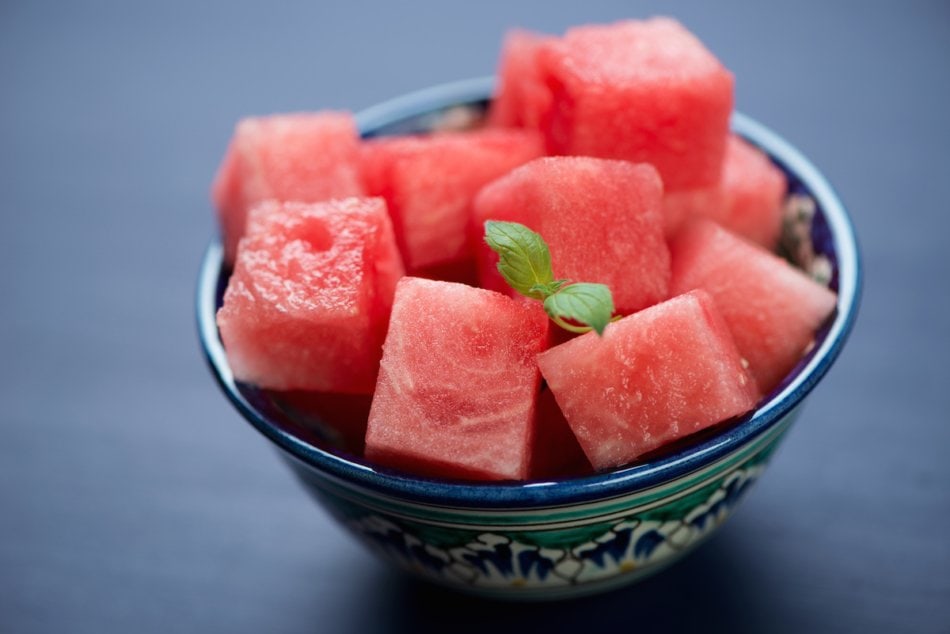 Watermelon cubes in a bowl with mint sprigs.