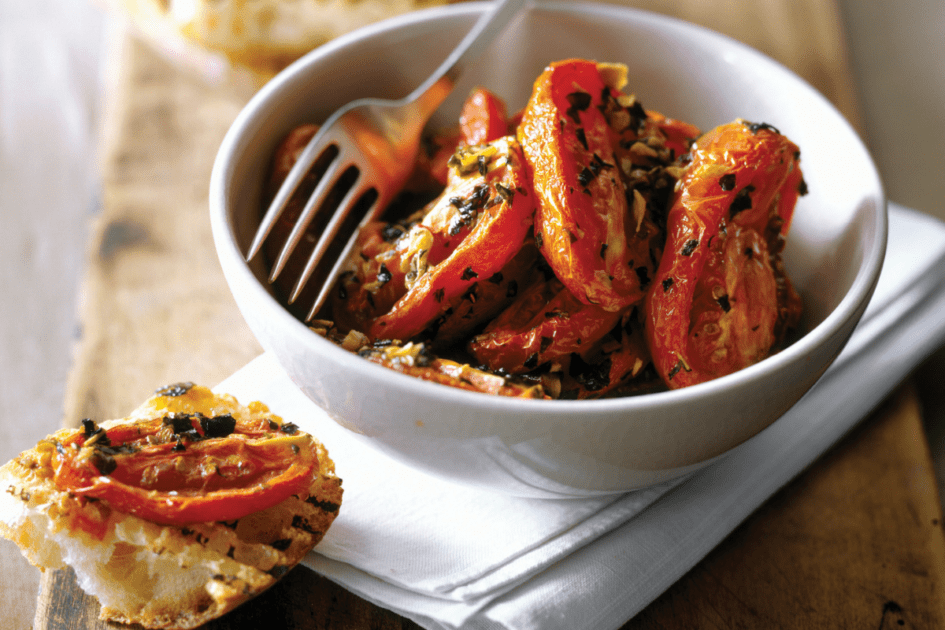 Grilled tomatoes in a bowl with garlic toast