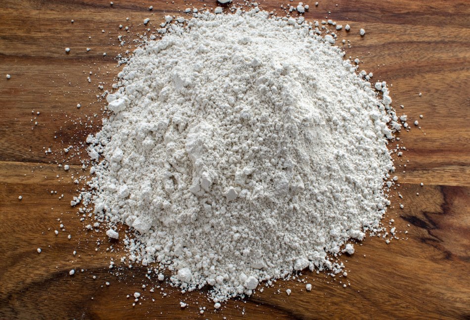 Pile of diatomaceous powder on a wooden table.