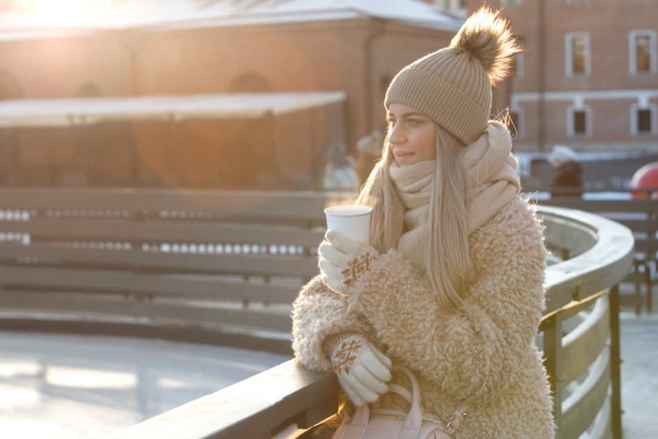 Woman in the cold with steaming coffee, Canada.