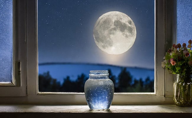 Moon water on a window sill under the full Moon.