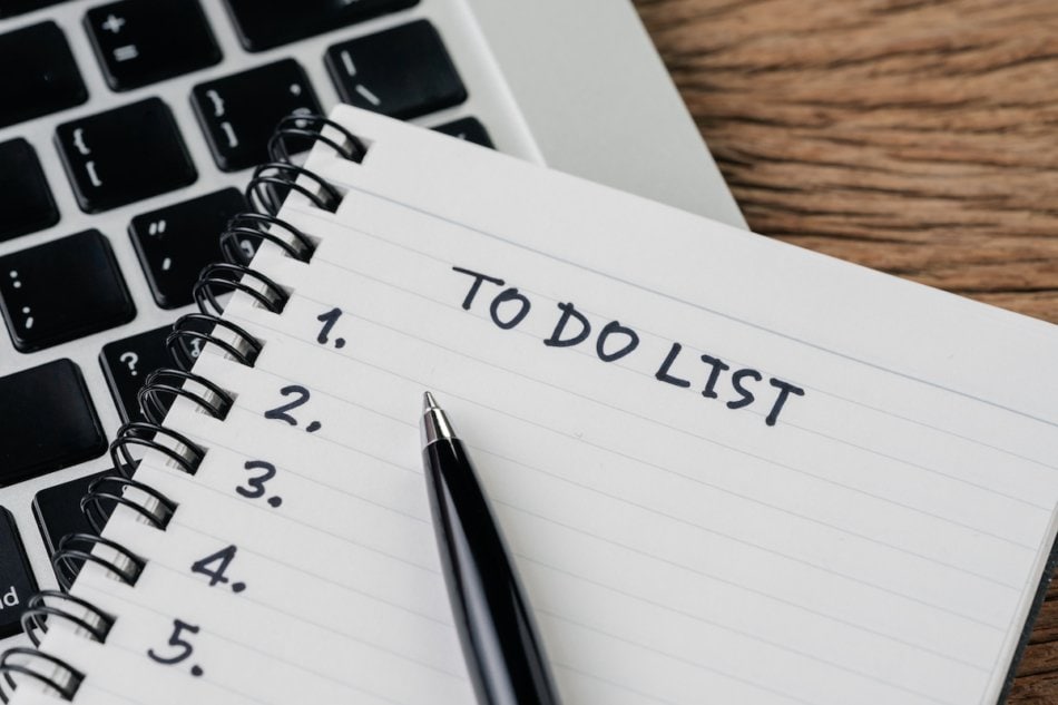 To do list, checklist of things or tasks to complete for life habit, business project plan concept, black pen on notepad with headline To do list and list of numbers on computer laptop, wooden table.