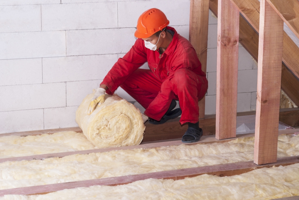 worker insulates the attic with mineral wool insulation