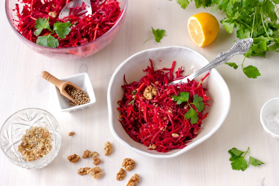 Healthy raw vegan beetroot salad with carrot and walnuts in a bowl on white wooden table. Natural organic food concept. Healthy diet.