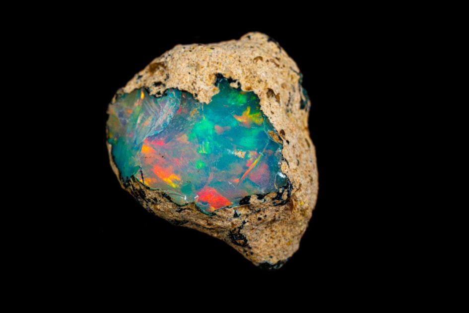 macro mineral stone rare and beautiful opals on a black background close-up.