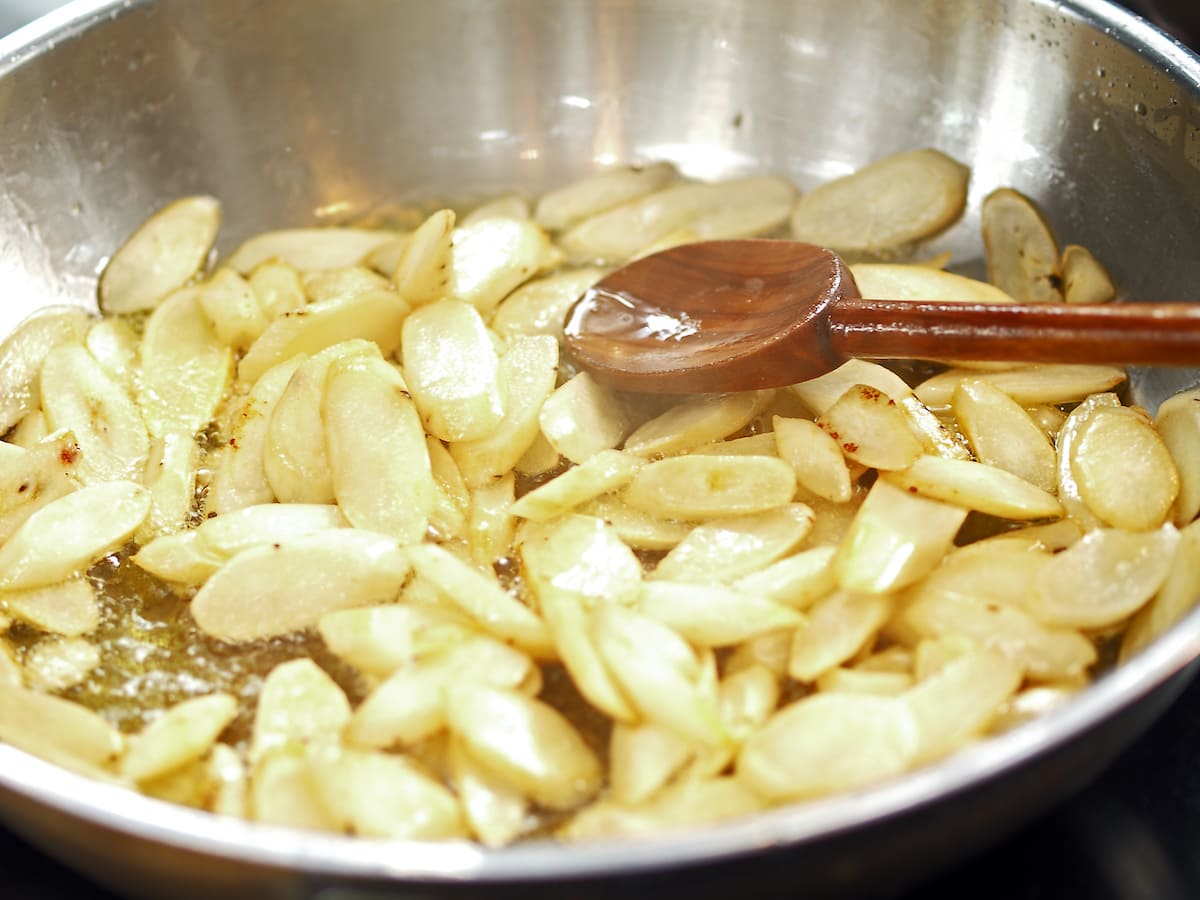 Pan-roasted salsify pieces with parsley on a serving plate.
