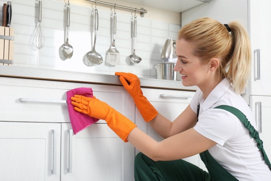 Woman cleaning cabinets.