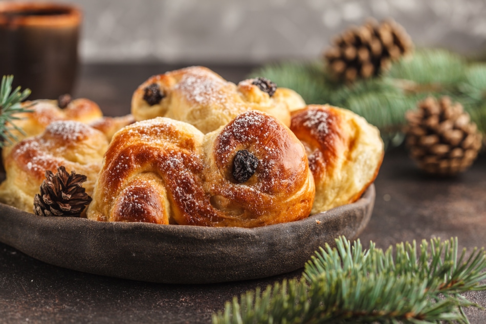 Traditional Swedish Christmas saffron buns (lussebulle or lussekatt). Swedish christmas. Dark background, Christmas decoration.