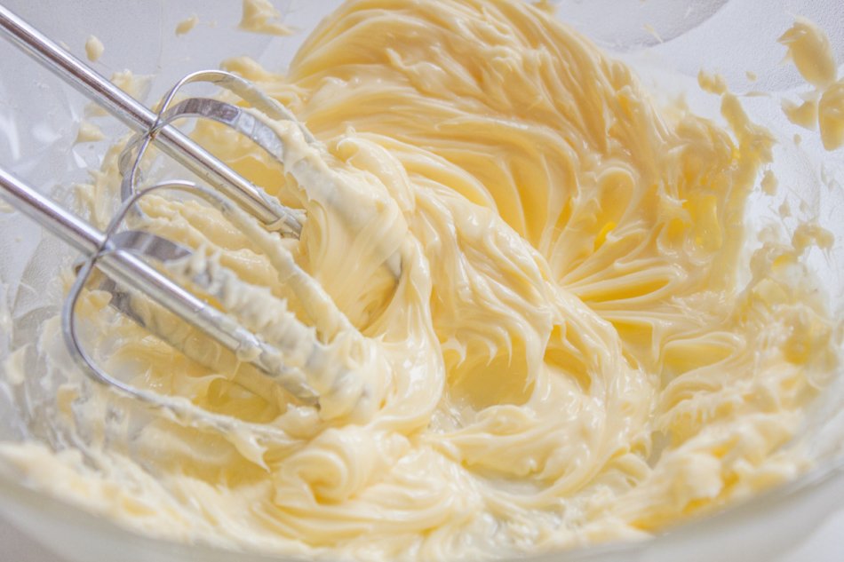 whisking butter, in a bowl full of butter and egg yolks.
