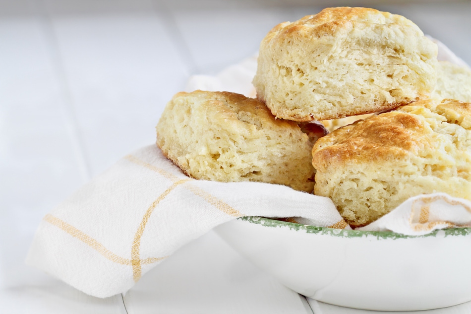 Fresh buttermilk southern biscuits or scones from scratch in a white bowl.