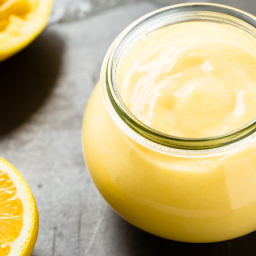 Homemade lemon curd in glass jar.