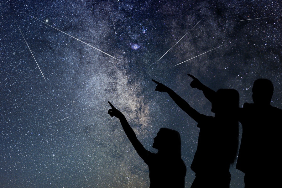 A family witnessing a meteor shower with shooting stars together.
