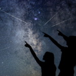 A family pointing at a meteor shower.