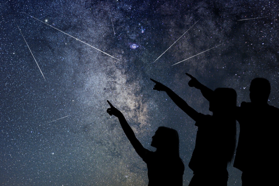 A family pointing at a meteor shower.