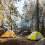 Two tents pitched at Yosemite National Park demonstrating camping on a budget.