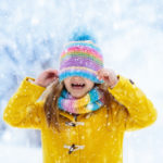 A girl in a yellow jacket enjoying Canadian weather 2021-2022.