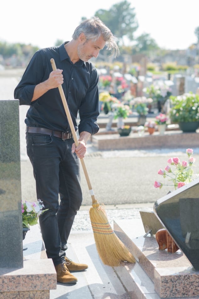 Gravestone being cleaned with a soft brush.