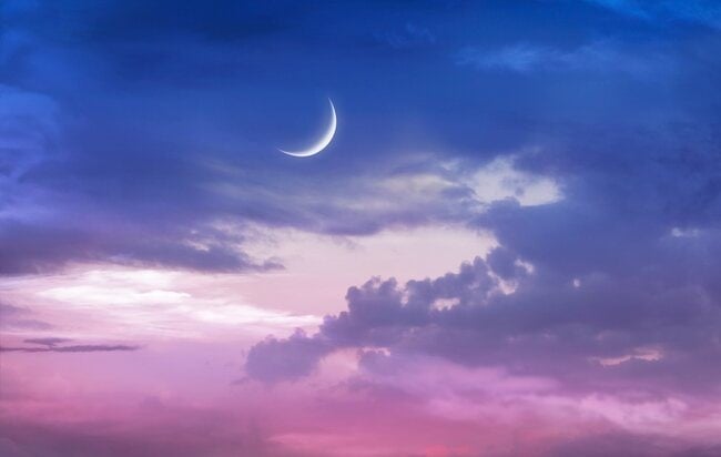 a new Moon in a twilight sky.