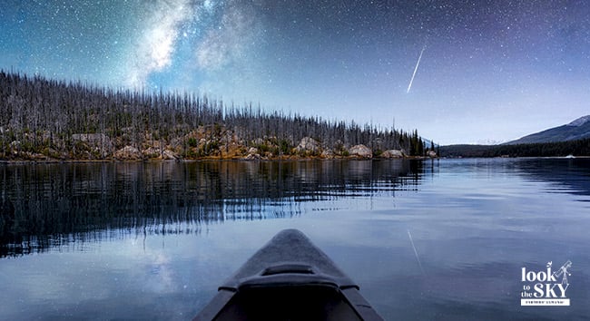 The November night sky at dusk with a kayak and shooting stars.