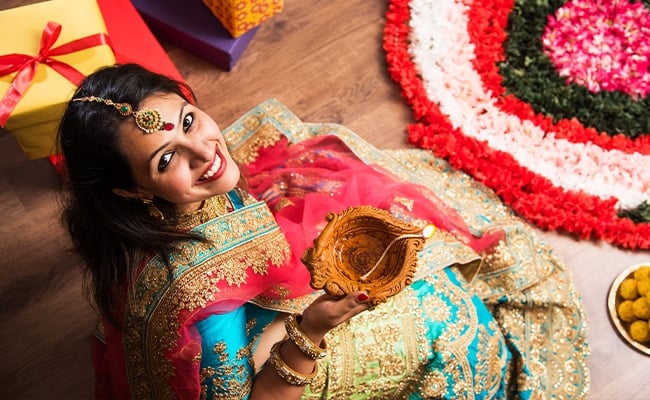 Diwali wishes represented by a woman with a candle.