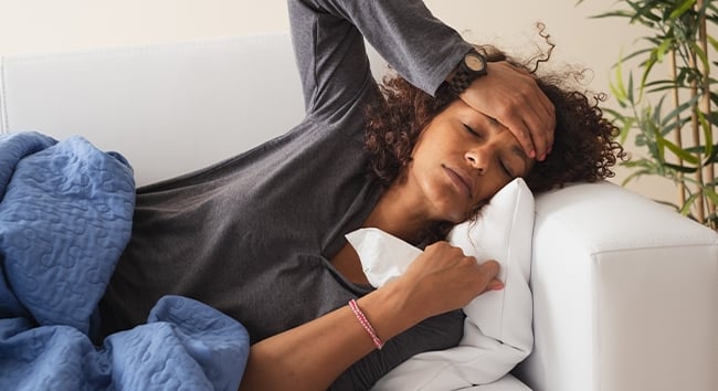 Woman with a fever to symbolize feed a cold starve a fever.