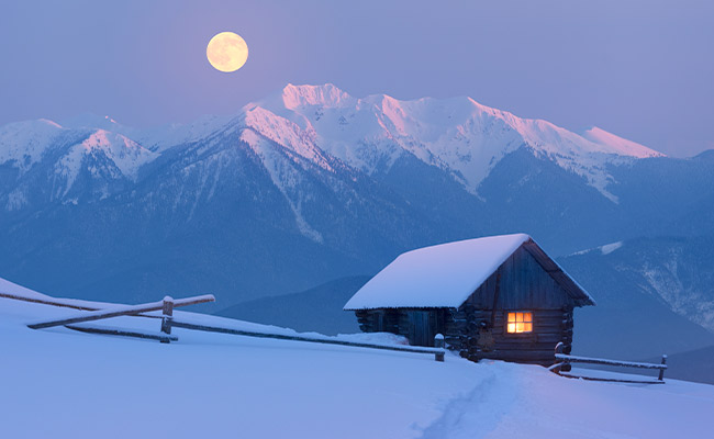 Full Snow Moon at twilight in a February sky.