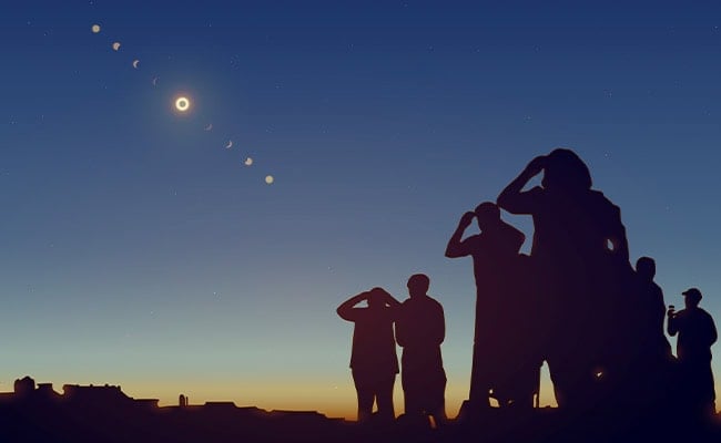 Eclipse 2024 at totality with people watching through Solar Eclipse Glasses.