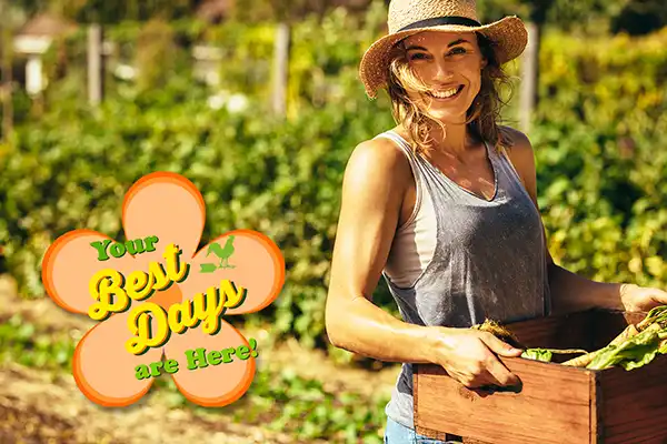 Farmers' Almanac planting calendar represented by a woman carrying a box full of harvested vegetables in a garden.