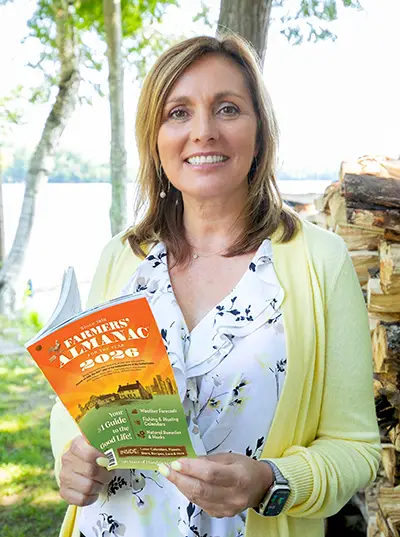 Editor Sandi Duncan holding Farmers' Almanac 2026.