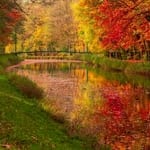 Scenic autumn scene with colorful fall foliage reflected in a river.