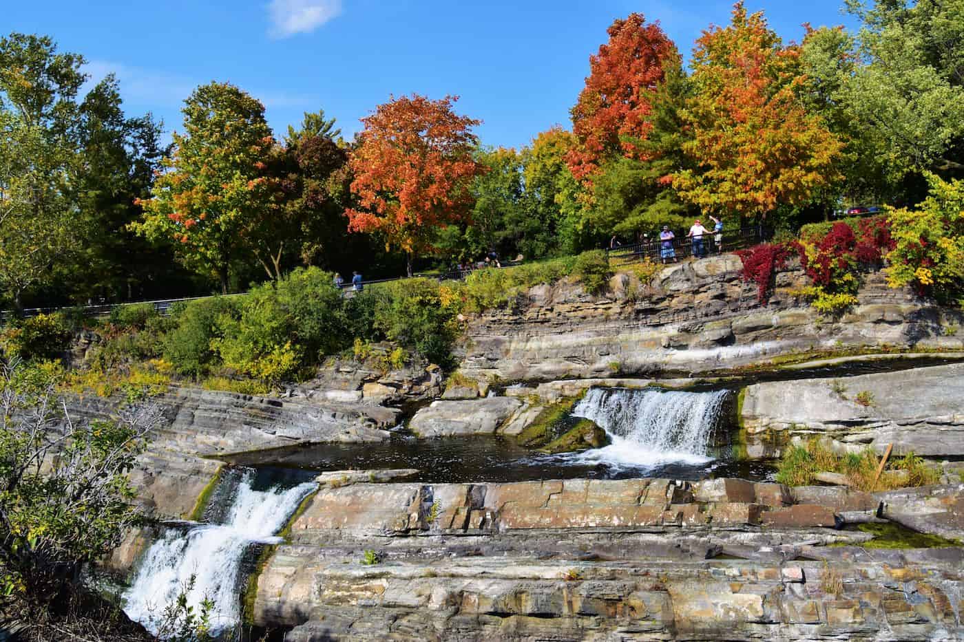 Scenic waterfall surrounded by colorful fall trees in autumn.