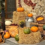 Decorative pumpkins and hay bales for Halloween front porch decor.
