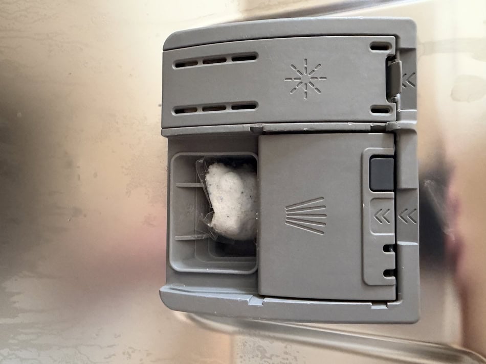 Automatic soap dispenser with foam soap in a kitchen or bathroom setting.