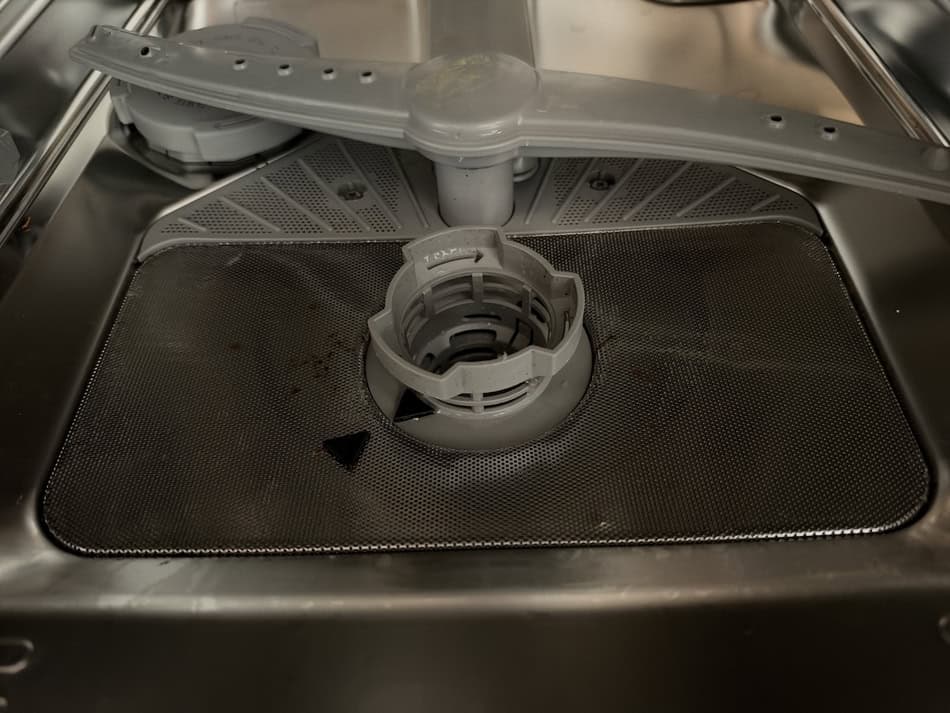 Empty washing machine drum with central agitator and clean interior.