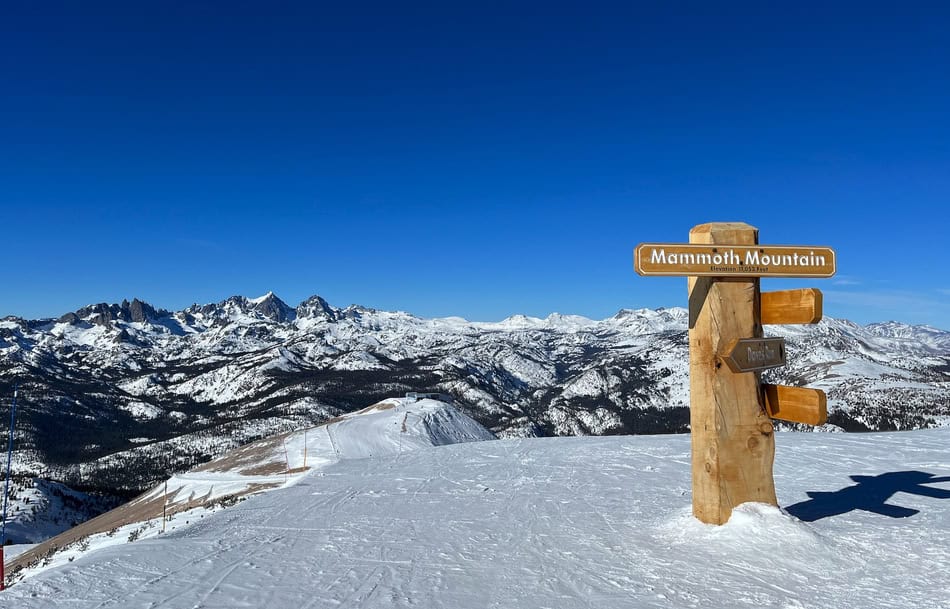 Snow-covered mountain landscape with Mammoth Mountain sign in winter.