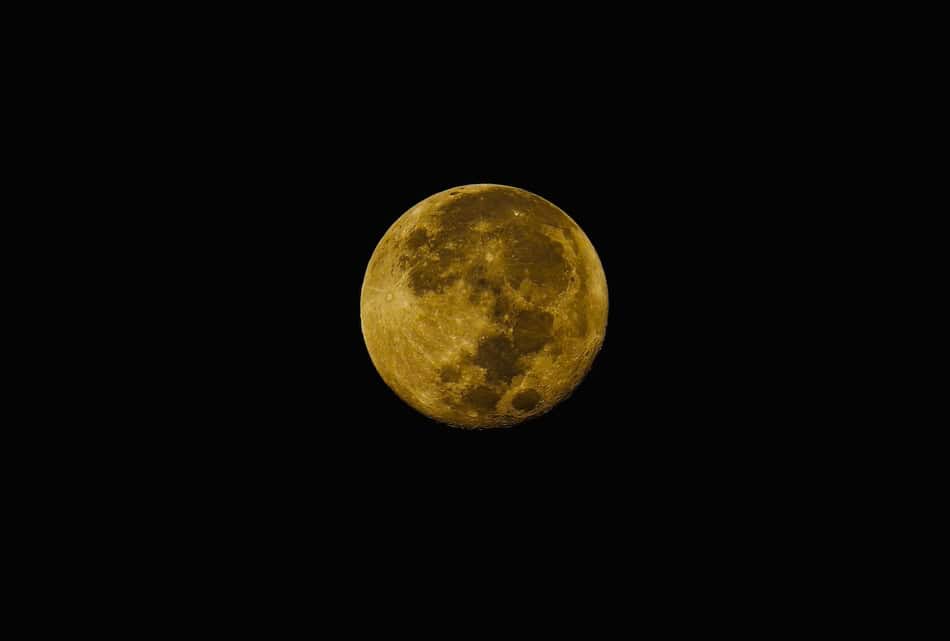 Bright yellow full moon against a dark night sky.