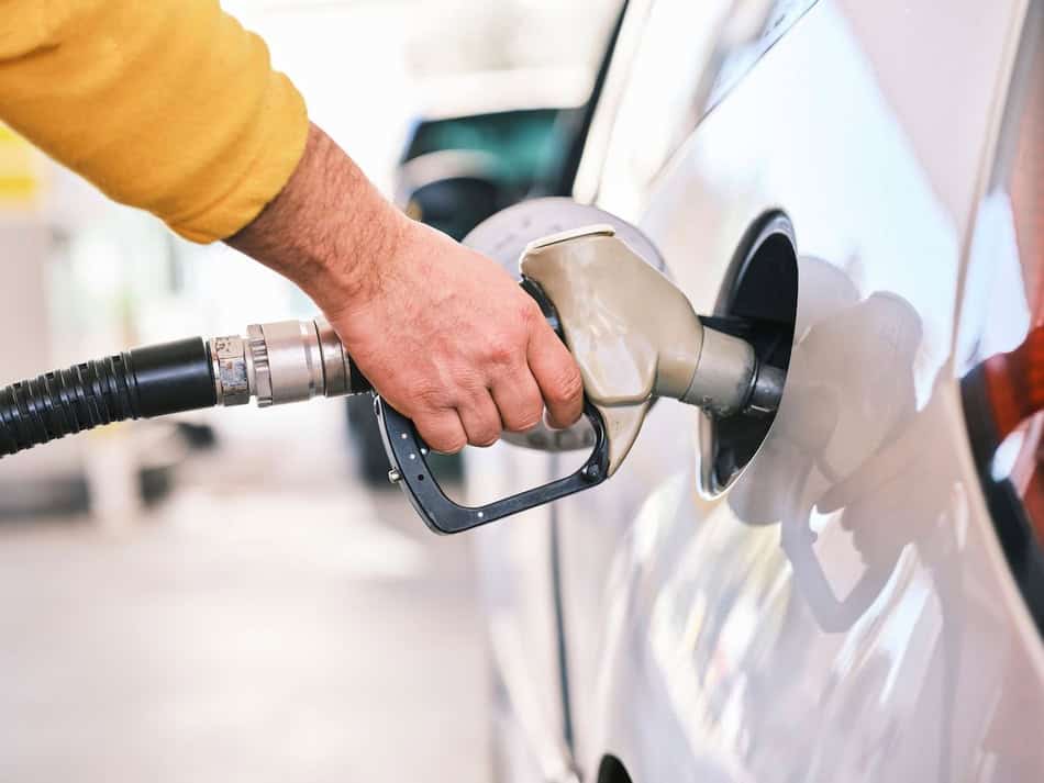 Person refueling car with gas pump in cold weather.