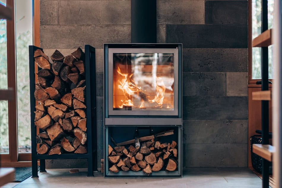 Contemporary wood stove with organized firewood storage in a cozy home setting.