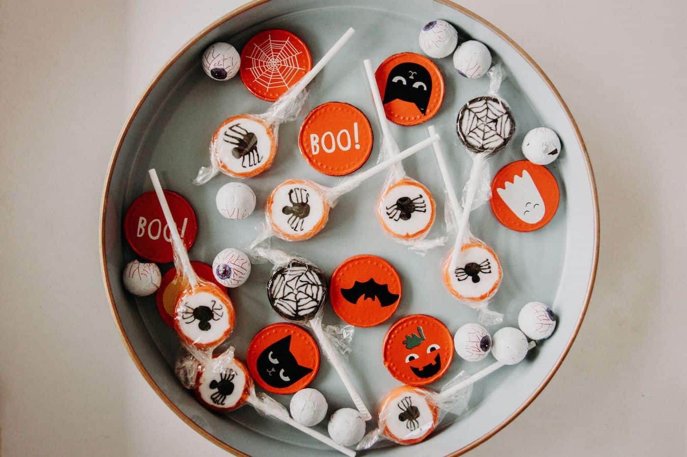 Seasonal Halloween candy toppers and lollipops arranged on a plate for a festive treat